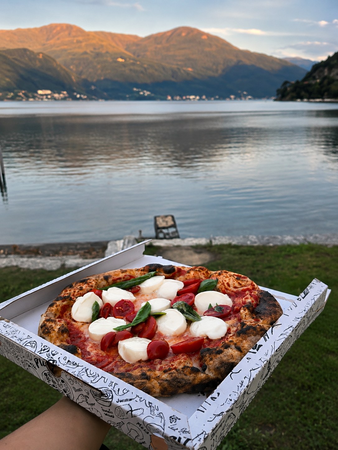 Margherita con bufala e pomodorini in riva al lago di Lugano al tramonto